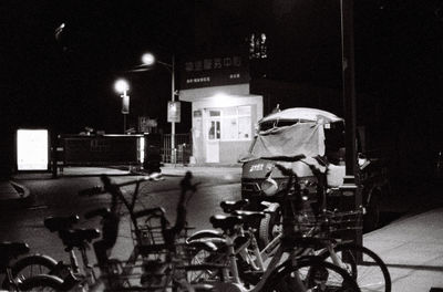 Bicycle parked on illuminated street at night