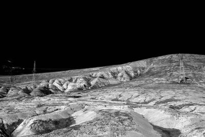 Snow covered land against clear sky at night