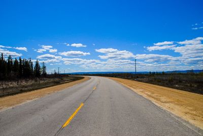 Road passing through landscape against blue sky