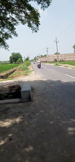 Cars on road against sky in city