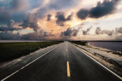 Surface level of road against cloudy sky