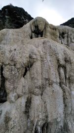 Low angle view of rock formation against sky