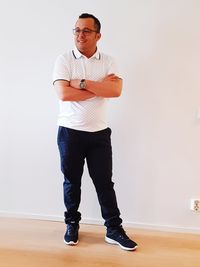 Portrait of young man standing against wall