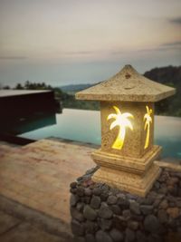 Close-up of illuminated candles against sky
