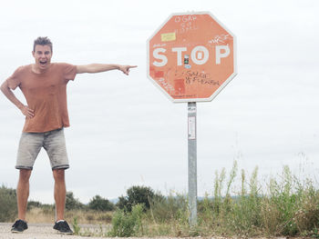 Close-up of young man with road sign 