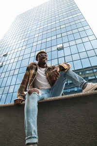 Low angle view of woman on building against sky