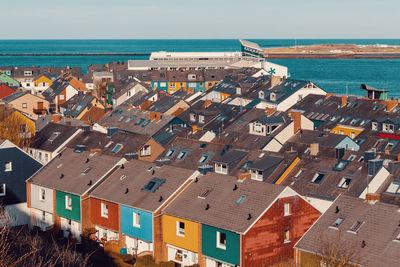 High angle view of townscape by sea against sky