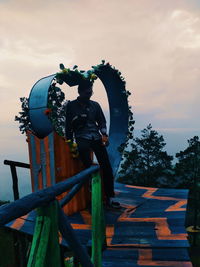 Statue against trees and sky during sunset