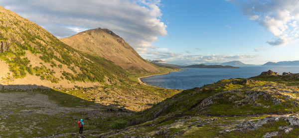 Hiker on mountain against sky at lyngseidet