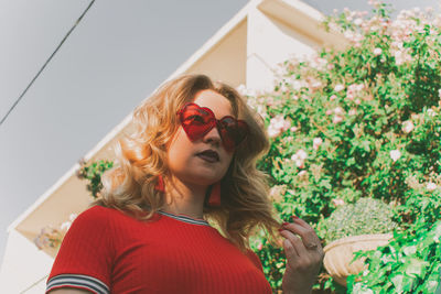 Young woman looking away while wearing heart shape sunglasses