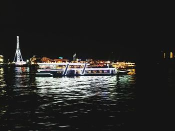 Boats sailing in river at night