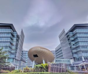 View of skyscrapers against cloudy sky
