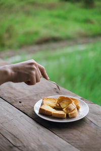 Midsection of person holding ice cream on table