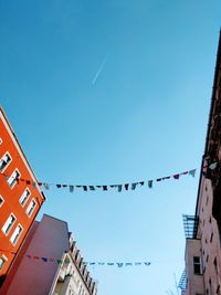 Low angle view of decorated buildings against clear blue sky