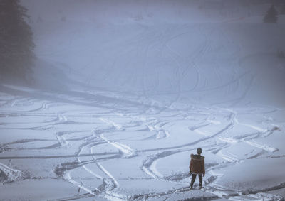 Ski slope under the mist with silhouettes