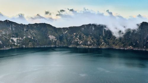 Scenic view of lake by mountains against sky