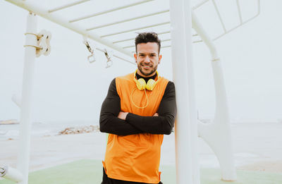 Athlete with arms crossed leaning on pole