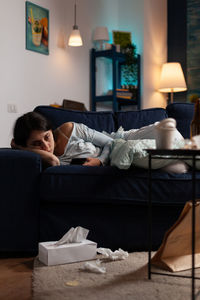 Portrait of young woman lying on bed at home