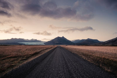 Diminishing perspective of empty road against sky during sunset