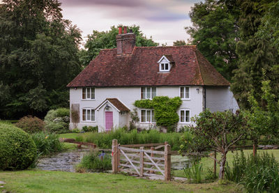 House amidst trees and buildings against sky