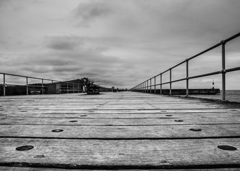 Footbridge over city against sky