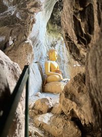 Rear view of woman sitting on rock formations