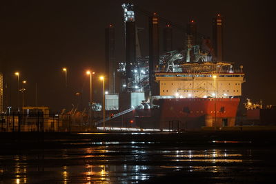 Illuminated commercial dock against sky at night