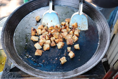 The food in a pan is fried radish cake or fried carrot is chinese made from steamed carrot cake