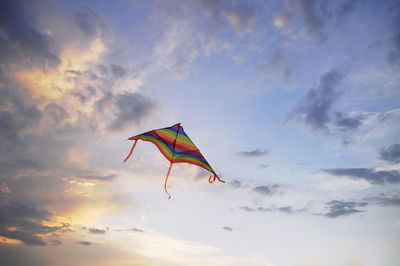 Low angle view of kite against sky during sunset