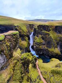 Scenic view of waterfall against sky