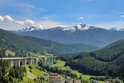 Scenic view of field and mountains against sky