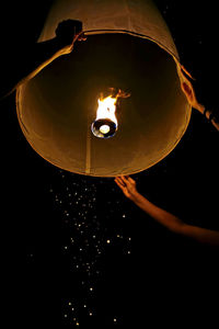 Low angle view of illuminated lantern against black background