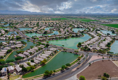 High angle view of city by river against sky