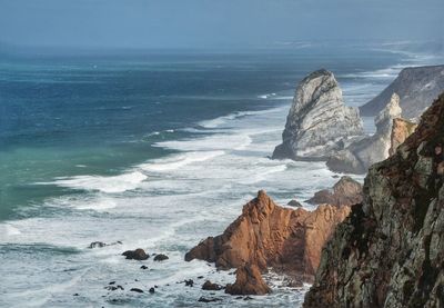 Scenic view of rocks in sea against sky