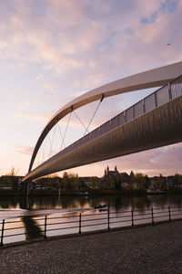 Bridge over river against sky during sunset