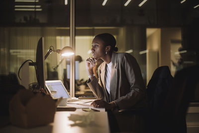 Businesswoman concentrating while working on computer overtime at work place