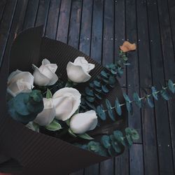 High angle view of rose flowers bouquet against boardwalk
