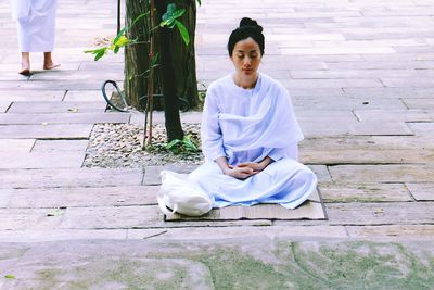 Full length of woman sitting outdoors