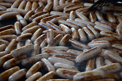 Full frame shot of sausages being fried for a large group of people