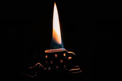 Close-up of lit candle in dark room