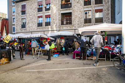 People walking on street against buildings in city