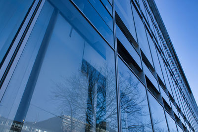 Low angle view of modern building against blue sky