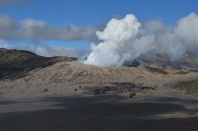 Smoke emitting from volcanic mountain against sky