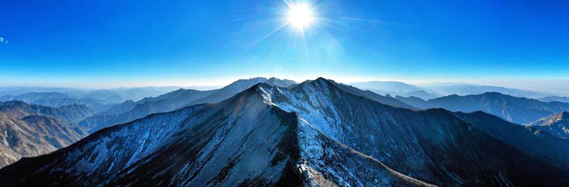 Scenic view of mountains against blue sky