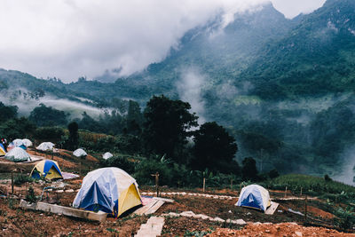 Tent in field against cloudy sky