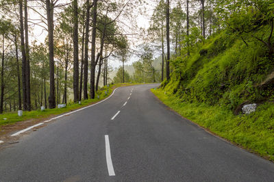 Road amidst trees in forest