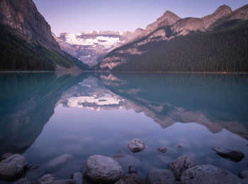 Beautiful alpine lake reflecting its surroundings,sunrise at lake louise, banff np, canada