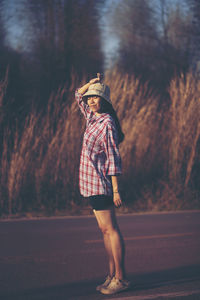 Woman with eyes closed standing on road