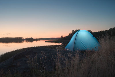 Glowing tent on the shores of a picturesque lake during the white nights
