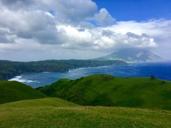 Scenic view of green landscape against sky